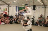 Jig2004_04 Matt Morris, dancing as Hell's Bells Morris jumping 
    over musician Gary O'Mahoney during the John Gasson Jig Competion at Sidmouth Festival 2004